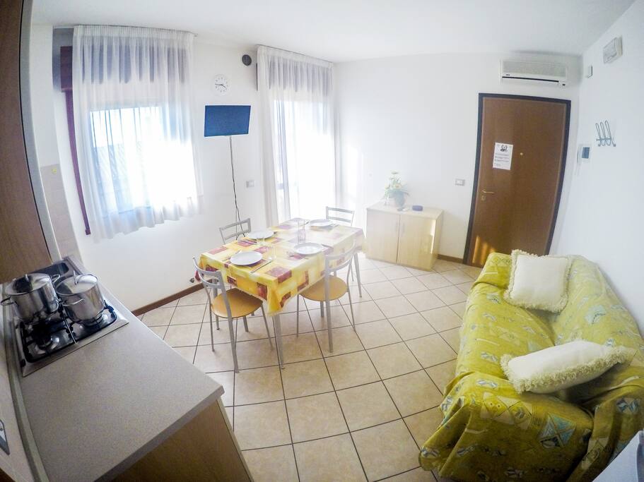 soggiorno con divano letto e angolo cottura