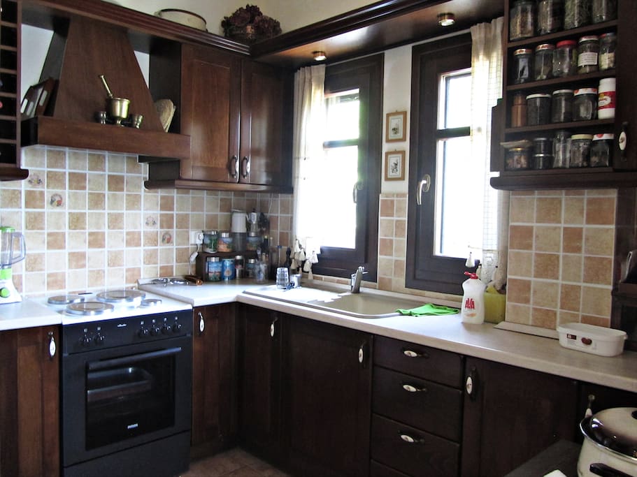 The kitchen with a coffee maker, a fridge, an oven and all the necessary equipment for cooking