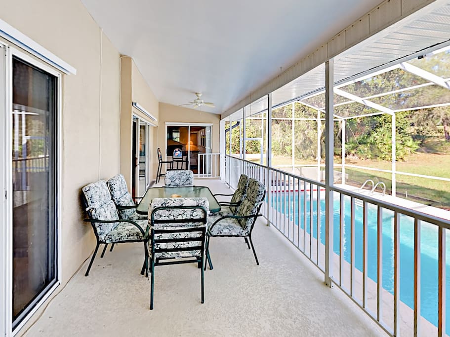 Dining area with seating for 6, overlooking screened pool.