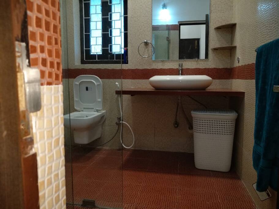 Private bathroom with glass shower stall and hot water geyser