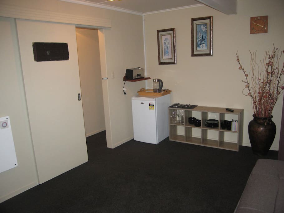 Lounge/kitchenette with sofa bed, TV, fridge, kettle, toaster, cutlery & crockery.
