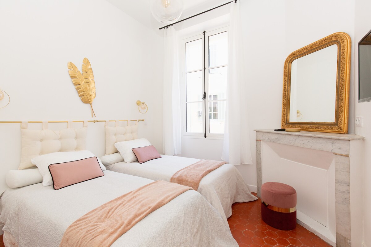 חדר שינה סגור עם שתי מיטות יחיד שניתן לדחוף יחד, ארון גדול וטלוויזיה.