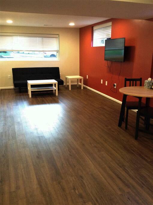 Living room with a sofa bed, TV, and 2 seat-dinner table