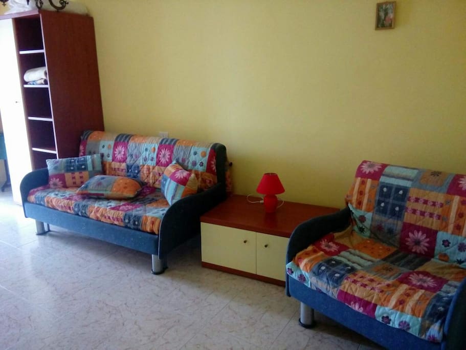 Salotto con due divani letto (tre posti letto in totale), armadio, Tv, balcone