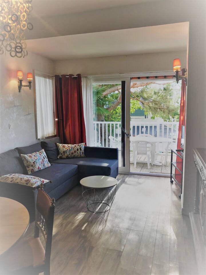 Living room overlooking a large terrace. Pleasant garden view.