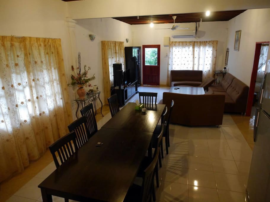 Relaxing indoor setup includes TV with Astro, 8 seat dining table and comfortable, well maintained couches.