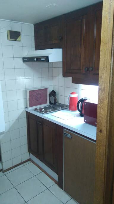 Cocina amoblada y con utensilios (hervidor, termo, microondas, mini refrigerador, ollas, loza, etc.).