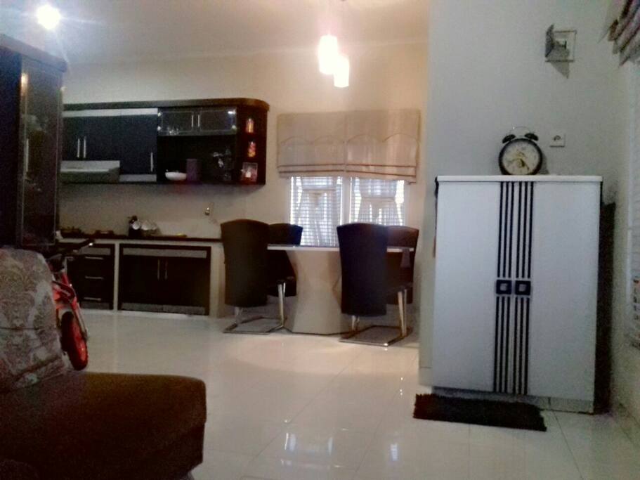 pintu rumah yang langsung terhubung dengan ruang tamu, dapur dan meja makan