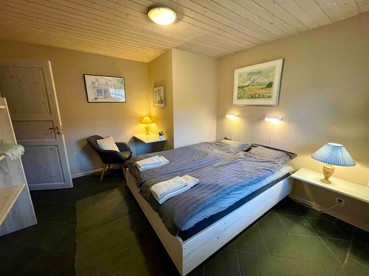 Chumba cha kulala cha sakafuni chenye kitanda mara mbili cha sentimita 160 na dawati dogo kwenye kona. 