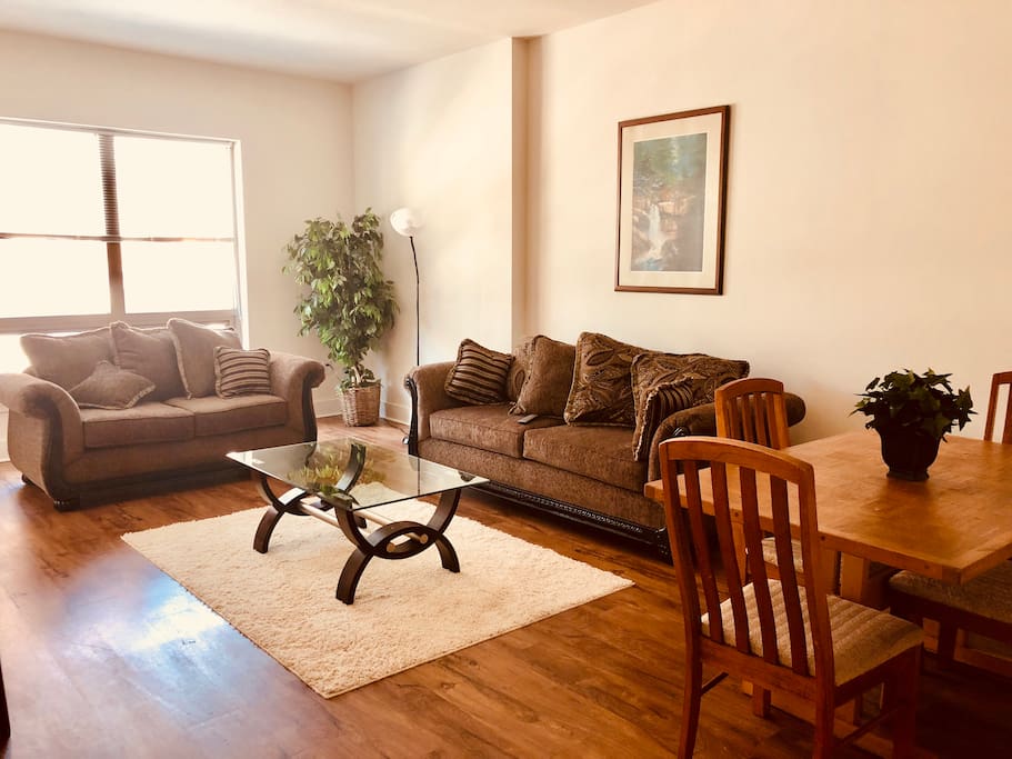Large, sunlit living and dining area. Dining table seats four. Comfy sofa and loveseat.