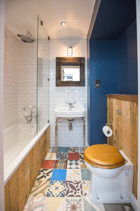 Modern en-suite bathroom with rainfall shower over bath and quality fittings & fixtures