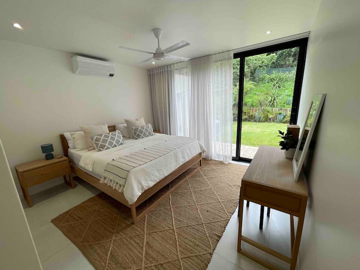 Segundo dormitorio con cama tamaño king extra, que se abre al área del jardín. 