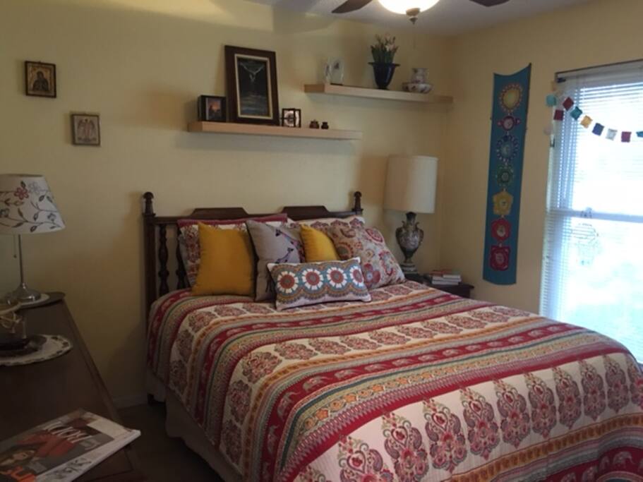 Downstairs bedroom has ceiling fan/light with west facing window view of street recieving warmth of sunrays.