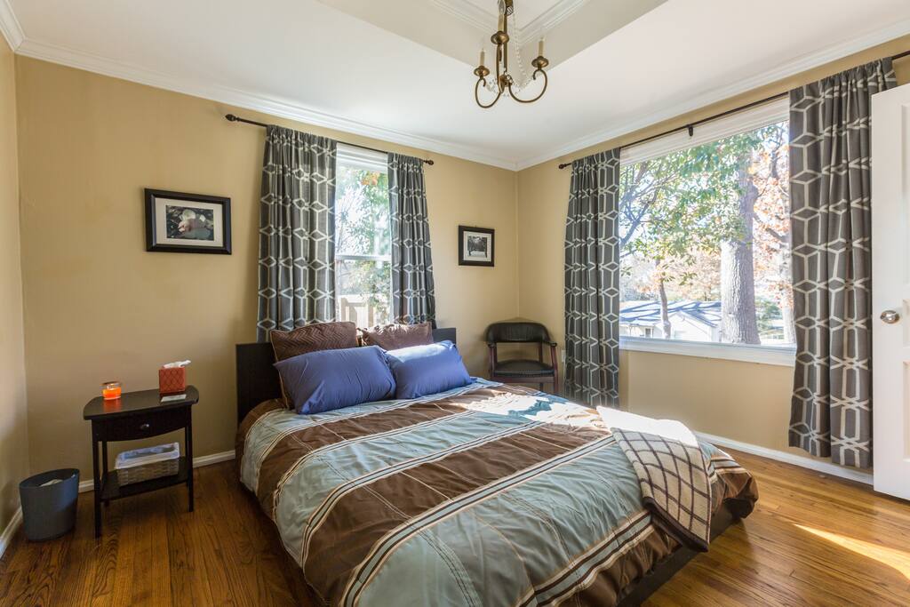 Homey bedroom with natural light and clean linens.