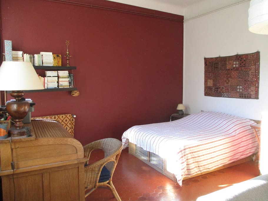 moustiquaire a une des fenêtre dans une grande chambre de 30m2 avec un bon lit