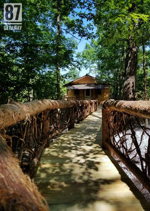 A grape vine adorned bridge leads you to the upper level of the 87Getaway Treehouse.