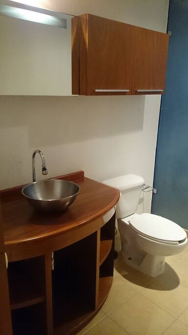 Baño amplio con regadera fija y de mano.
