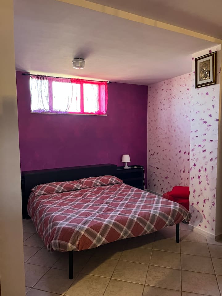 חדר שינה עם מיטה זוגית ושתי מיטות יחיד