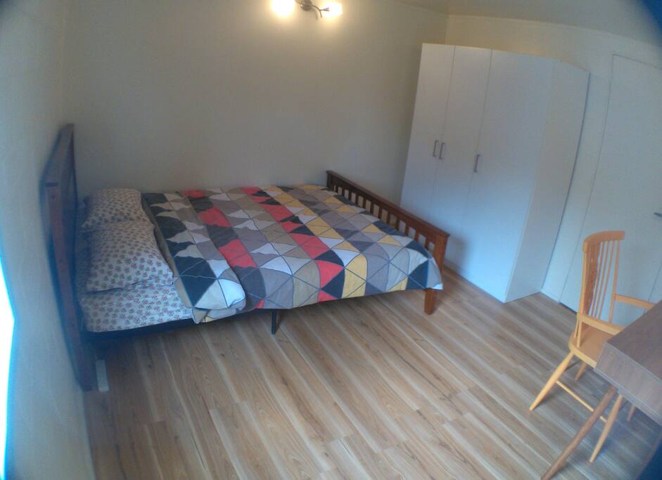 Room with double bed, desk and wardrobe