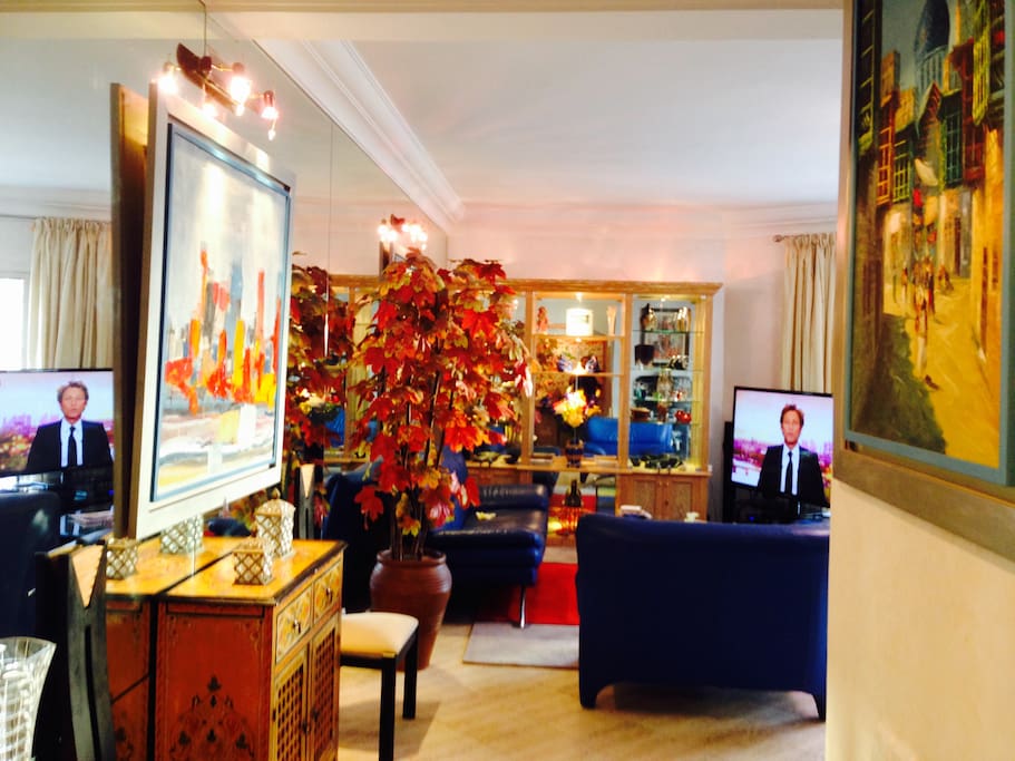 Vaste living luxueusement décoré avec écran géant, richement décoré