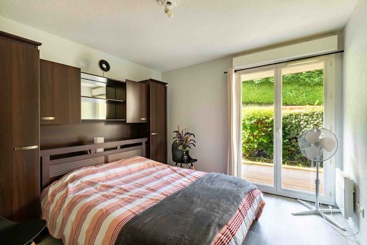 Quarto iluminado com cama de casal confortável, amplo espaço de armazenamento e acesso direto ao terraço. Bela abertura para o exterior, ambiente calmo e agradável, ideal para uma estadia relaxante.