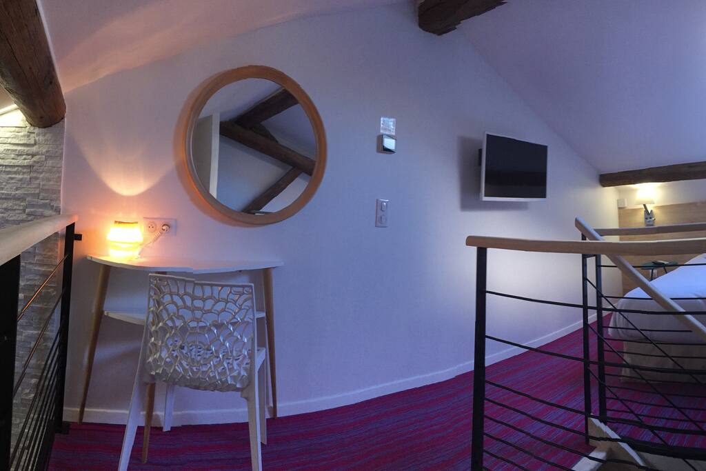 Mezzanine "sous les toits", poutres apparentes, espace cocoon, équipée d'un grand lit 160*200, TV, petit bureau et grande penderie et rangements. Velux avec télécommande.