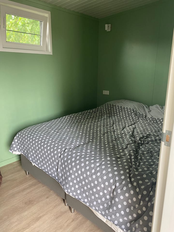 Slaapkamer 1, de groene kamer, met 2 boxspringbedden.