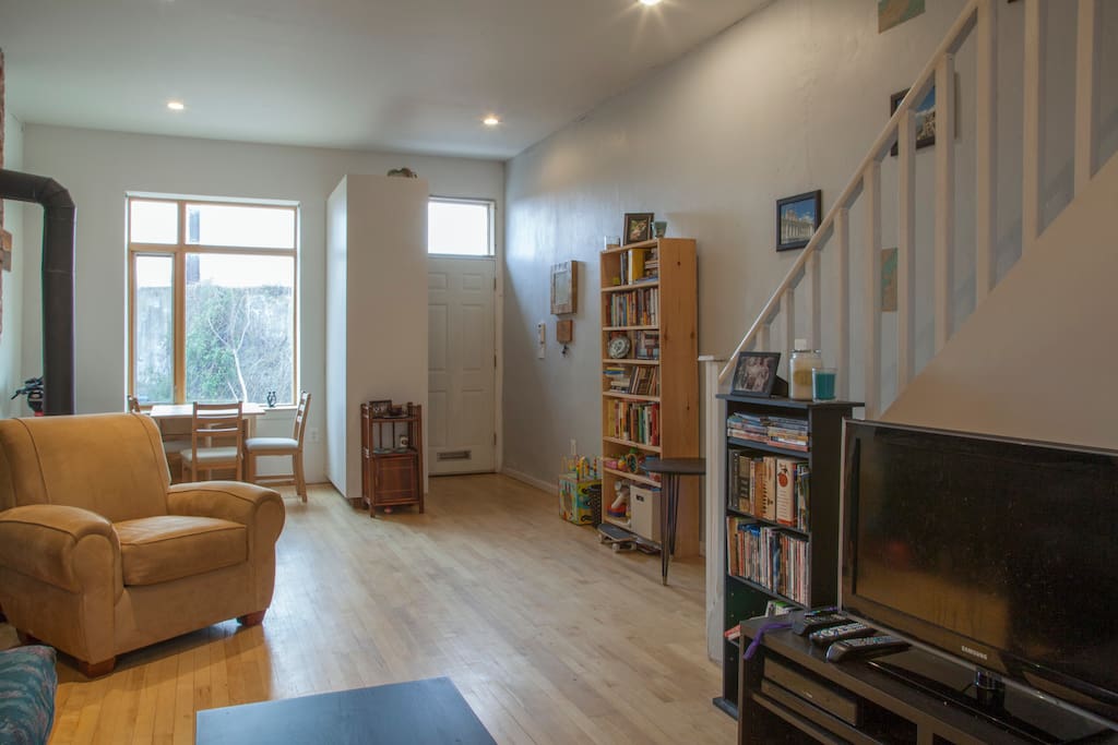 Open living room and dining area, TV has a Roku with Amazon Prime, HBO Go, and Netflix accounts.
