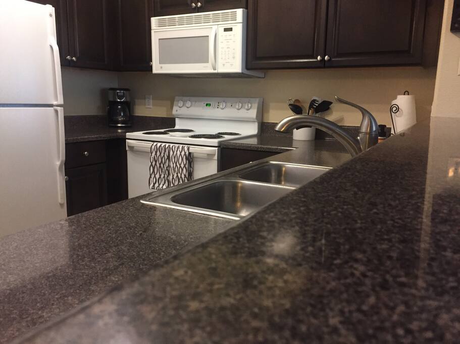 Kitchen, fully stocked with dishes, pots, pans, utensils and grilling essentials.