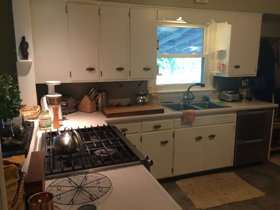 Kitchen with stainless and cast iron cookware and quality appliances including a juicer, stand mixer, food processor, and a 4-burner dual fuel convection range.