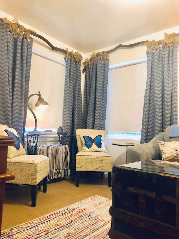 Here’s our cozy living room that features an end table with a phone charging station, desk, 43” smart tv, and even an essential oil diffuser with oils! Curtains chairs, couch & pillows are sprayed with Clorox brand sanitizer for colorfast fabrics. 