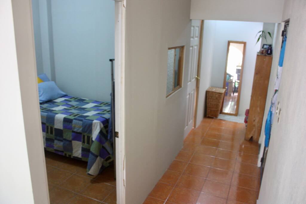 The door on the left at the end of the hallway is the host's bedroom. The entrance to the apartment and the bathroom area is on the right
