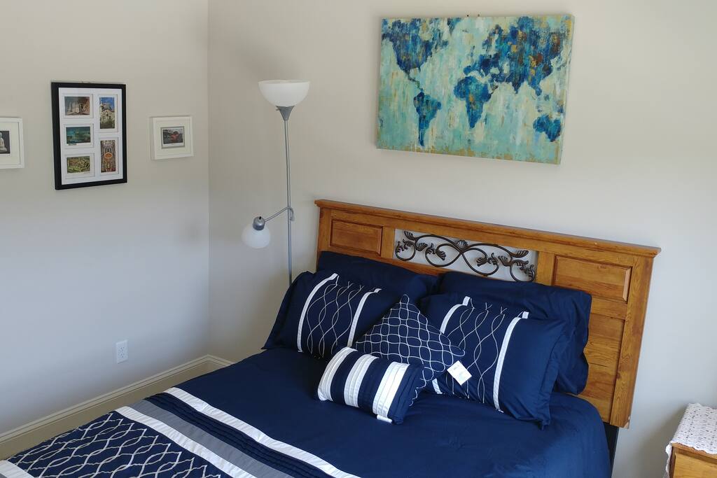 Queen size bed next to a shared full bathroom