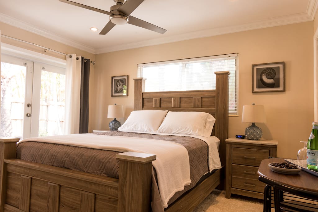 Queen sized bed with cafe table & french doors to the pool