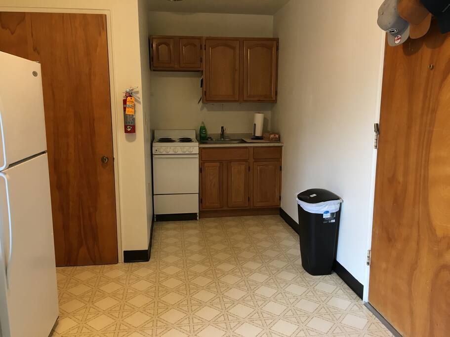 This is a fully functional kitchen with a stove, microwave and a fridge for additional purposes.