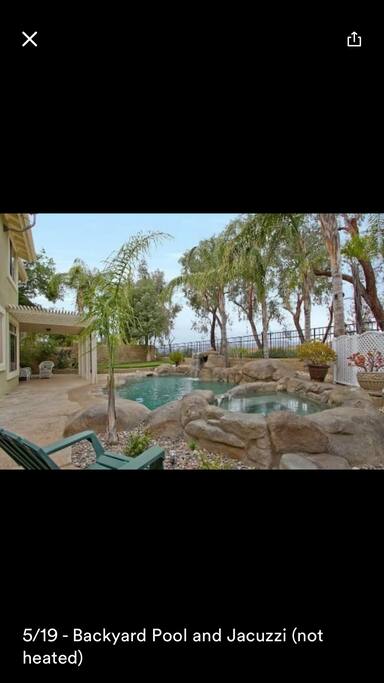Backyard with view, pool, jacuzzi and putting green.