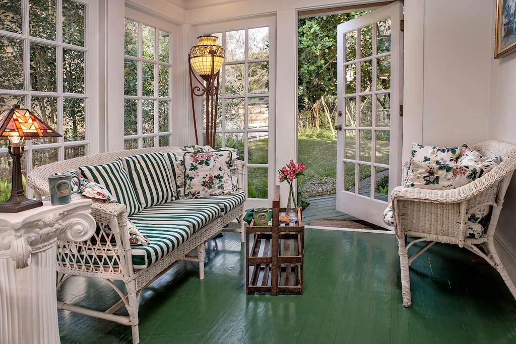 Beautiful and bright sunroom with seating and a dining room table.