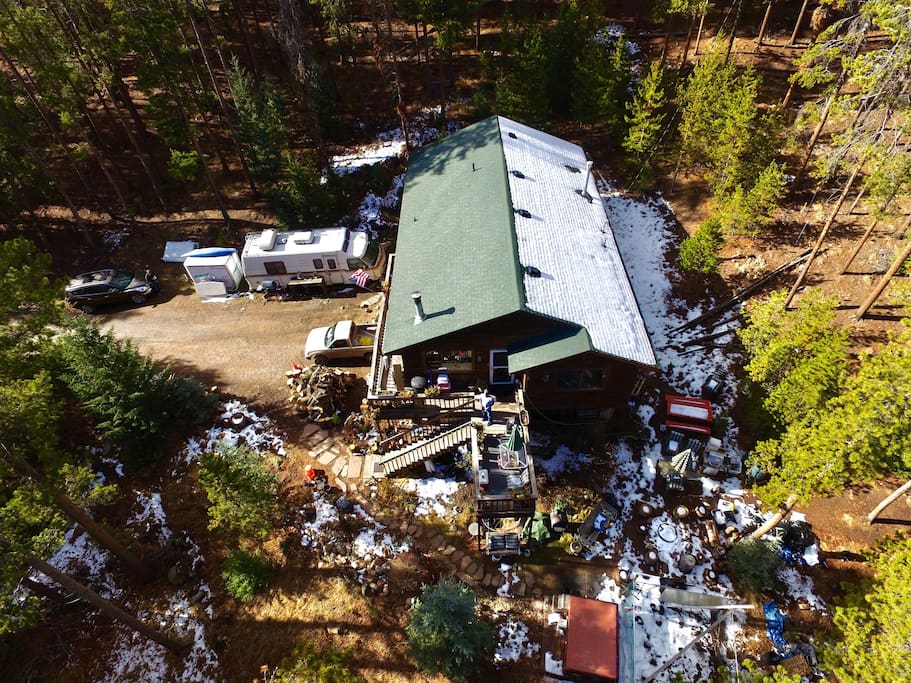 Drone photography of house showing surroundings and a bit of the forest & motor home