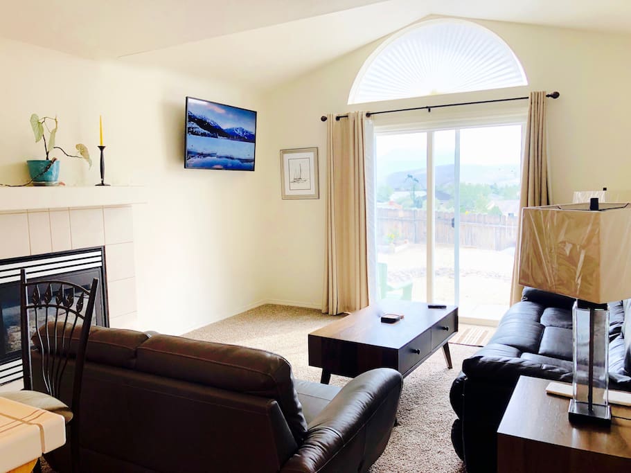 The family room has plenty of seating on comfortable leather couches, a gas fireplace, and a 4K television.