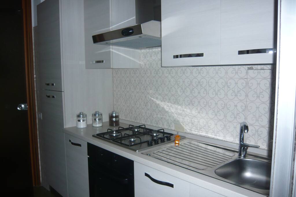 Cucina con forno, fornelli a gas, frigorifero.