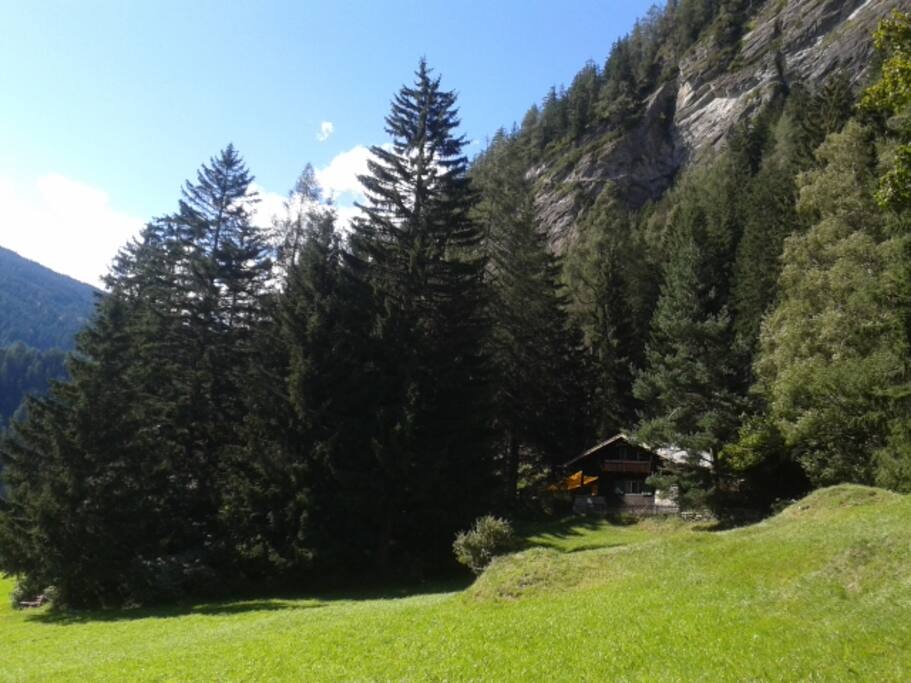 Im Hintergrund sieht man die Stafflacher Wand mit dem 2012 gebauten Klettersteig, der durch seine südseitige Lage fast das ganze Jahr begehbar ist und tolle Tief- und Weitblicke bietet. Rechts im Wald gibt es noch eine weitere Hütte.
---
In the background you can see the 'Stafflacher rock' with the via ferrata.
On the right in the forest is a second cottage.