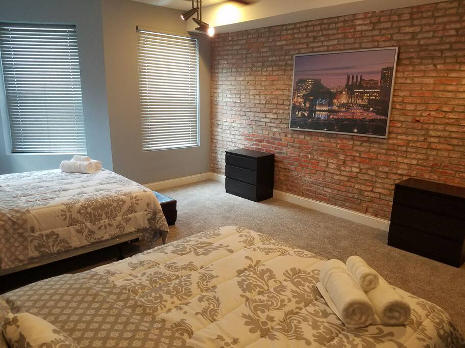 2 queen beds, exposed brick wall, small dressers