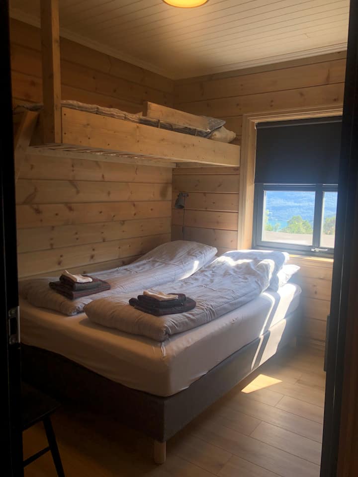 Chambre au premier étage avec un lit queen et un lit superposé simple.
