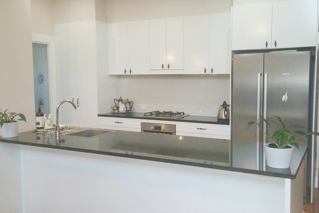 Kitchen fully-equipped with dishwasher, gas hotplates, oven, appliances, coffee machine, crockery, glassware and cutlery