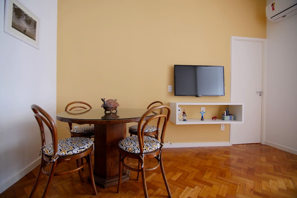 Sala com destaque para a TV e a mesa de jantar