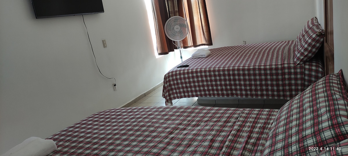 Spavaća soba 1, ima dva bračna kreveta, dva ventilatora i televizor.