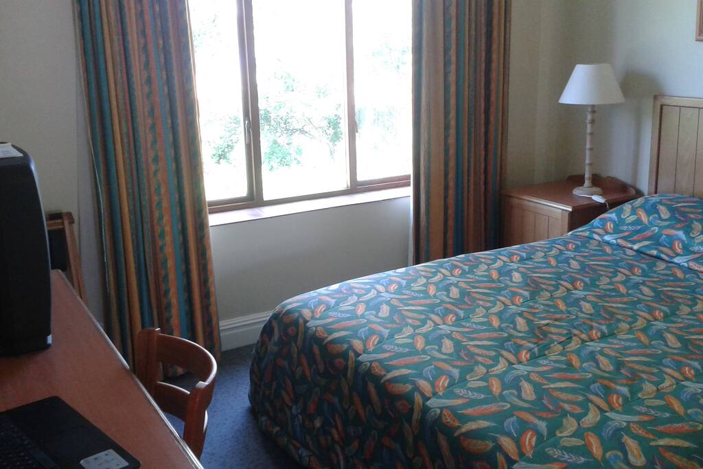 Bedroom 1 has a queen size double bed, desk, television, river view and shower in en-suite bathroom