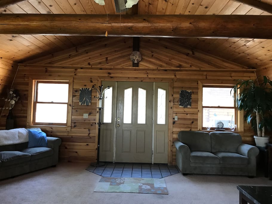 As you enter the great room, you will feel at ease with the warmth of wood lined walls and log beams.