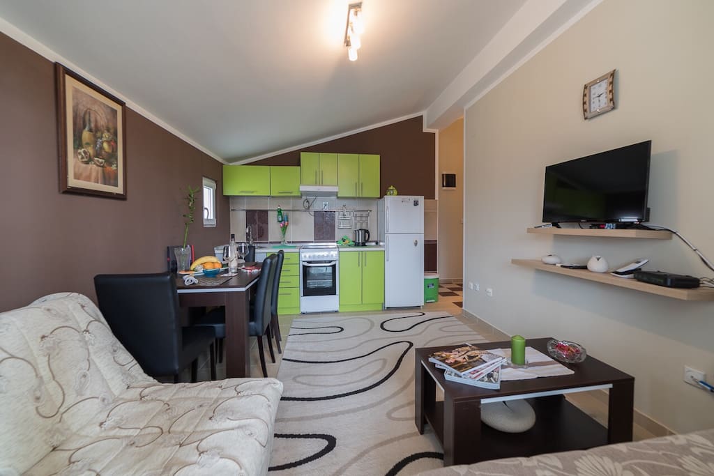 Our living room is cream/brown colours. Painted cream with brown, beige sofas. We have a marble fireplace. Ceramic flooring. The TV is on the wall. We have a coffee table in the middle of the room and side tables with a lamp.