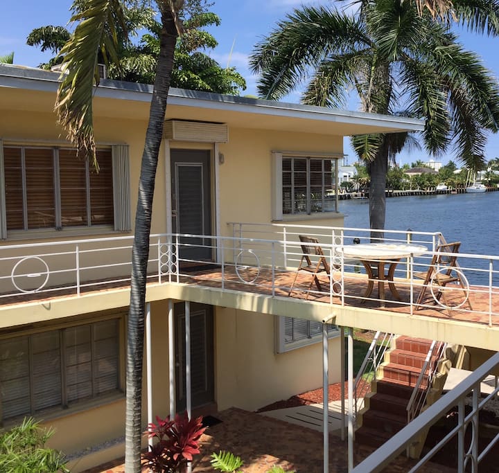 The apartment entrance on the upper floor, with a balcony outside.